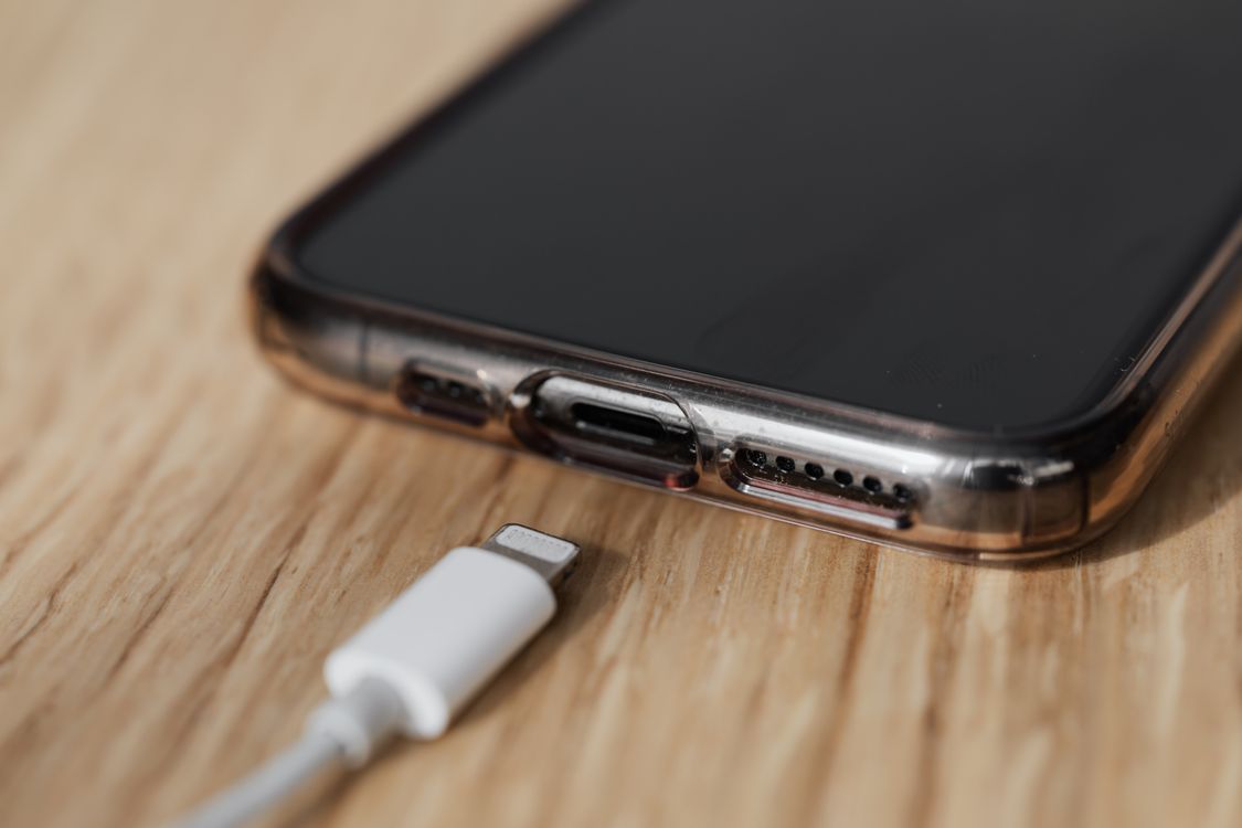 Nabíjecí kabel s konektorem položený vedle telefonu